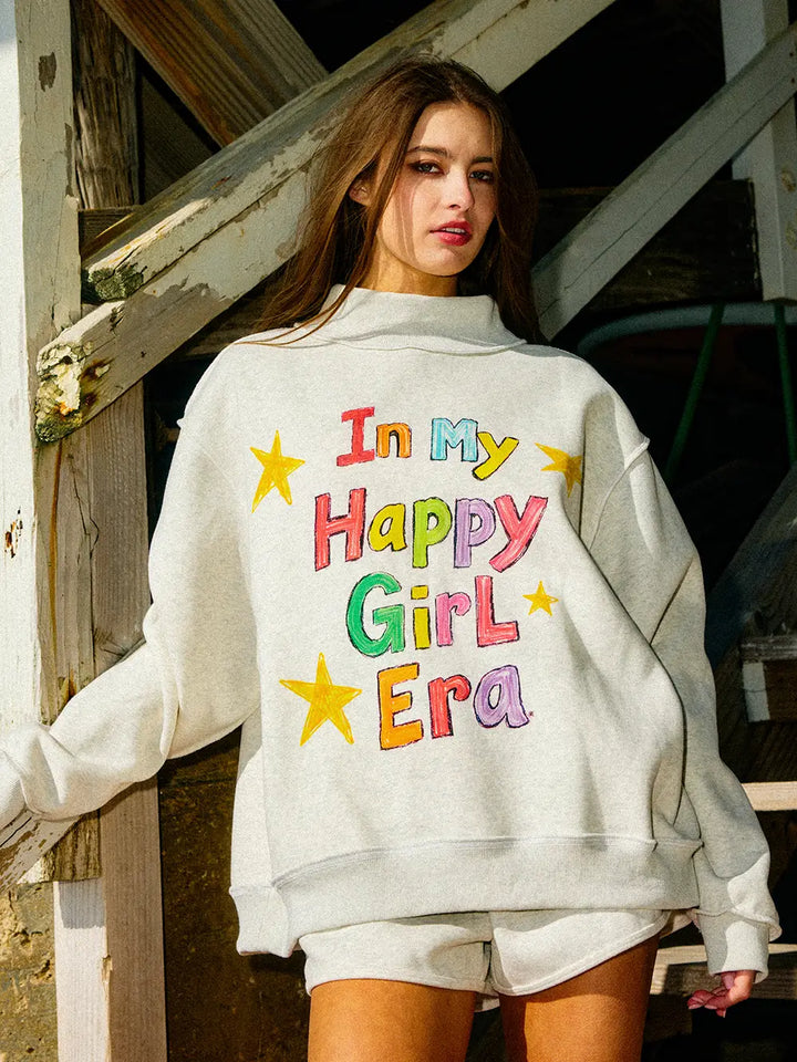 Person wearing a gray sweatshirt with colorful text &