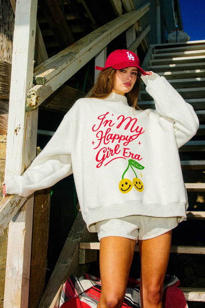 Person wearing a white sweatshirt with text and graphics, standing on wooden steps.