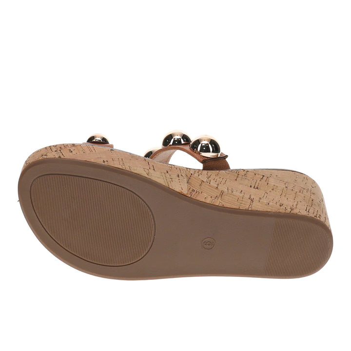 Cork wedge sandal with gold accents on a white background