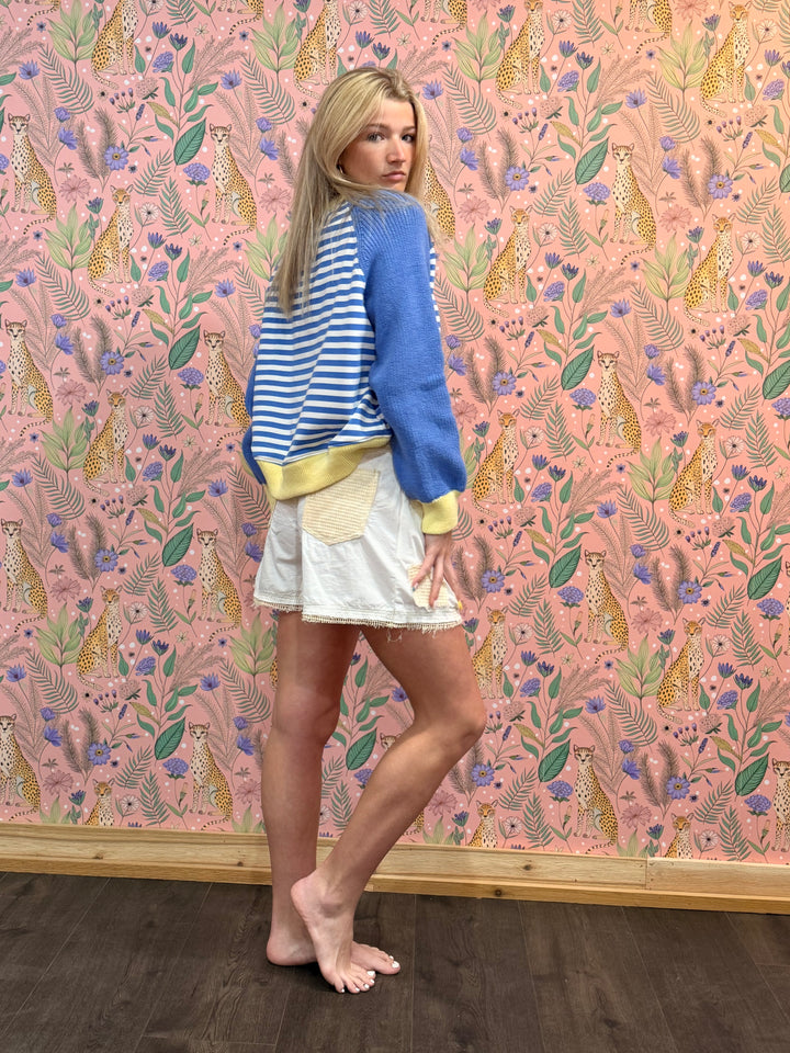Woman standing against a wall with a colorful animal pattern