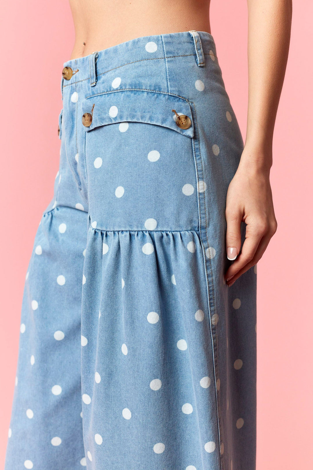 Denim skirt with white polka dots on a pink background