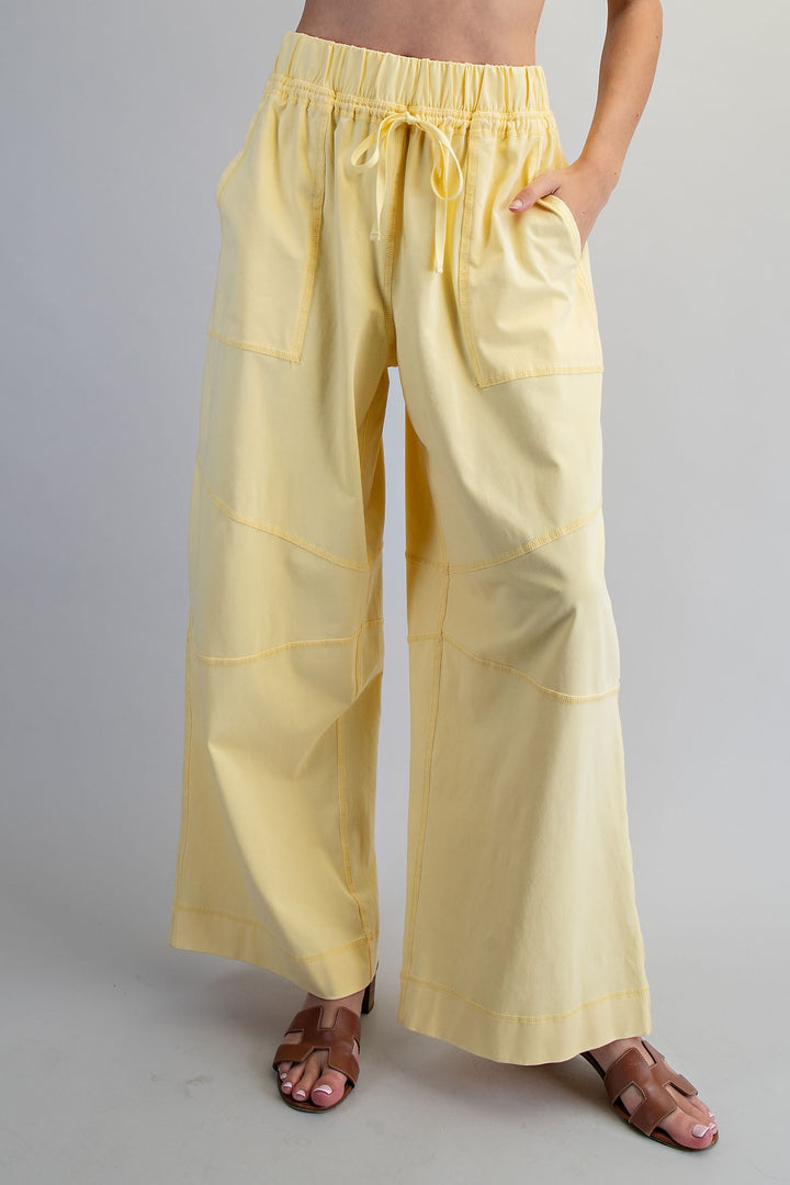 Yellow wide-leg pants worn by a person on a plain background