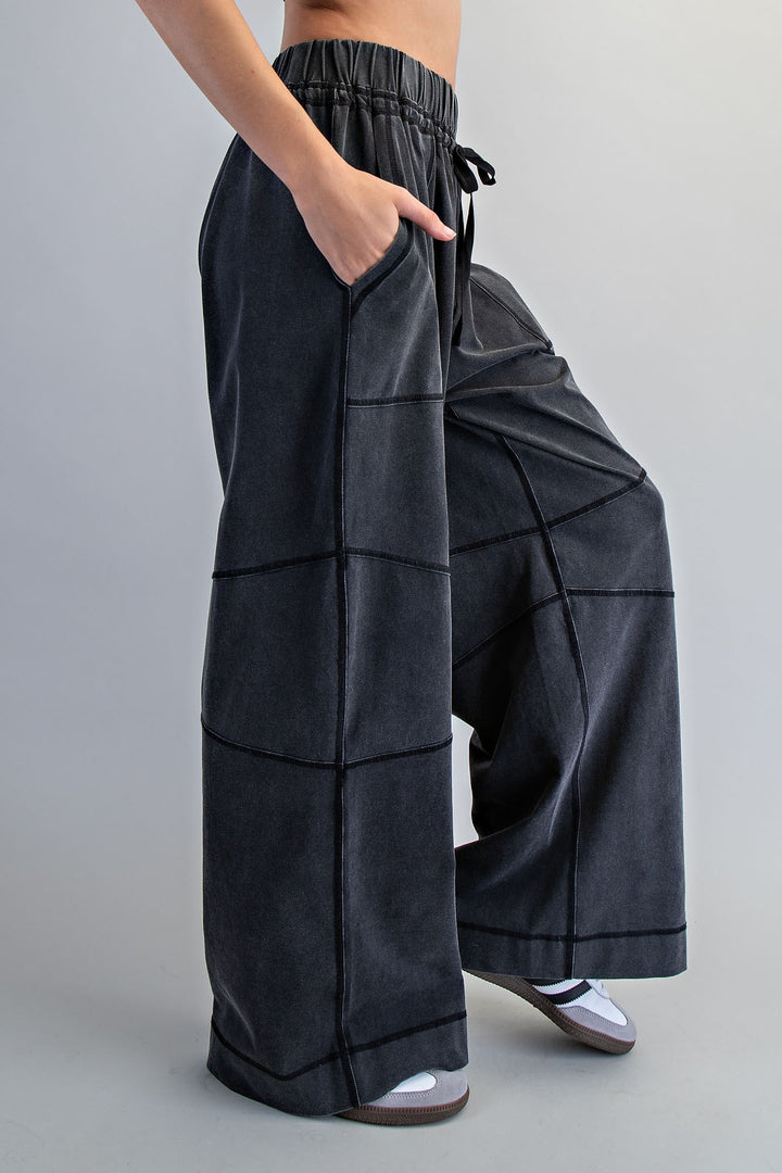 Dark gray wide-leg pants worn by a person on a plain background