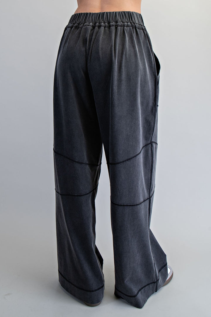 Black pants with wide legs and elastic waistband on a plain background