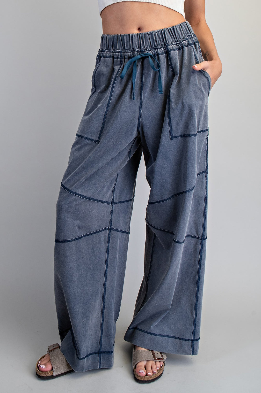 Blue wide-leg pants with a drawstring waist on a gray background