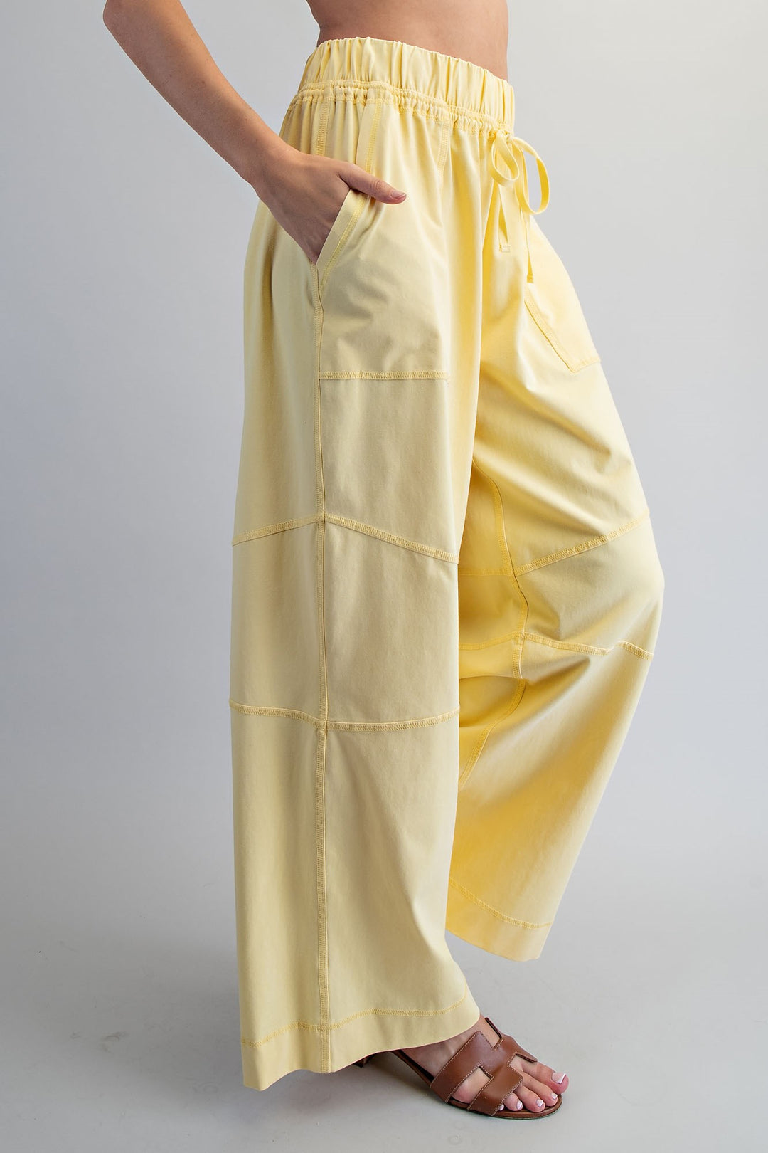 Yellow wide-leg pants worn by a person on a gray background