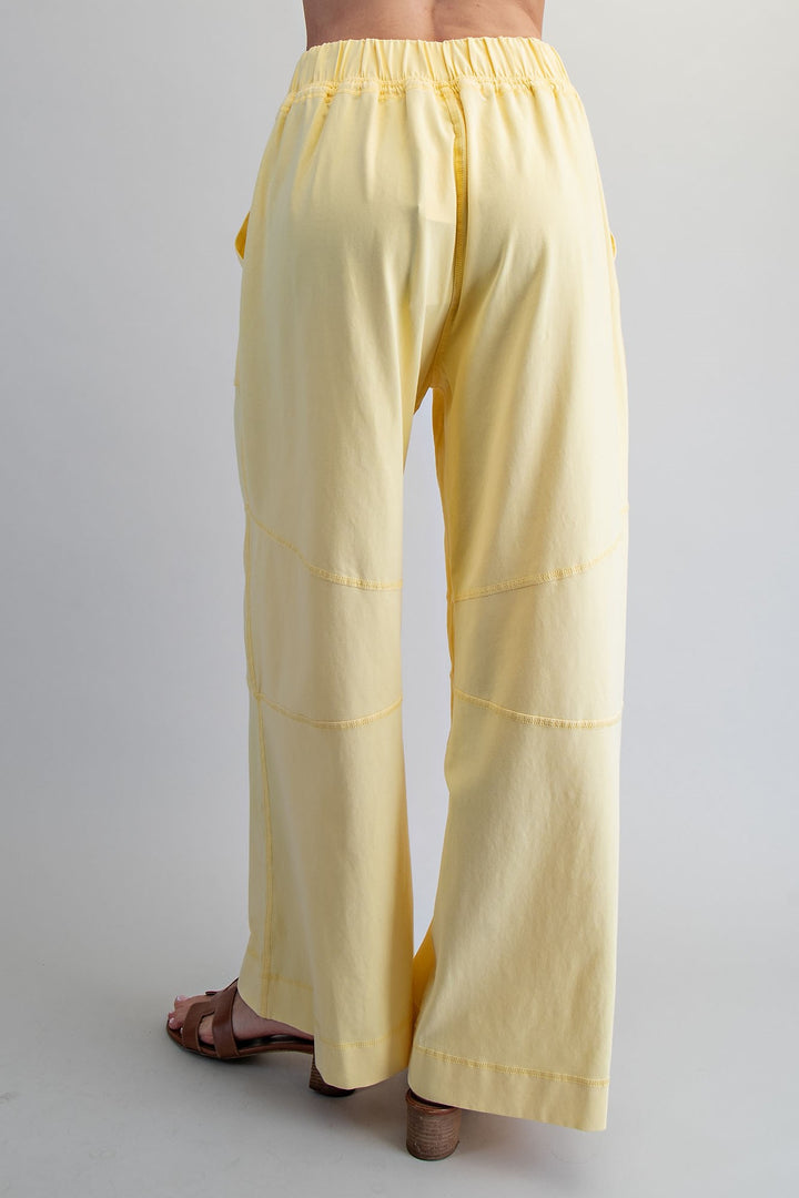Yellow pants worn by a person on a plain background