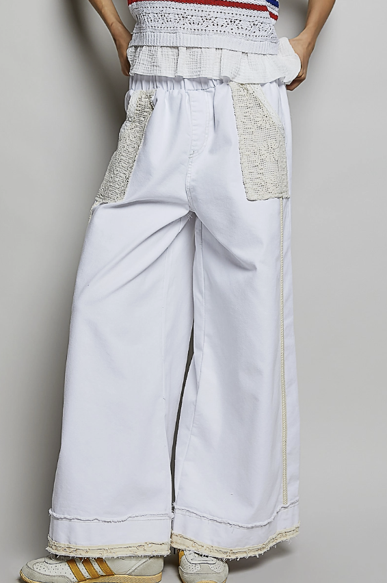 Woman wearing white and lace pants on plain background