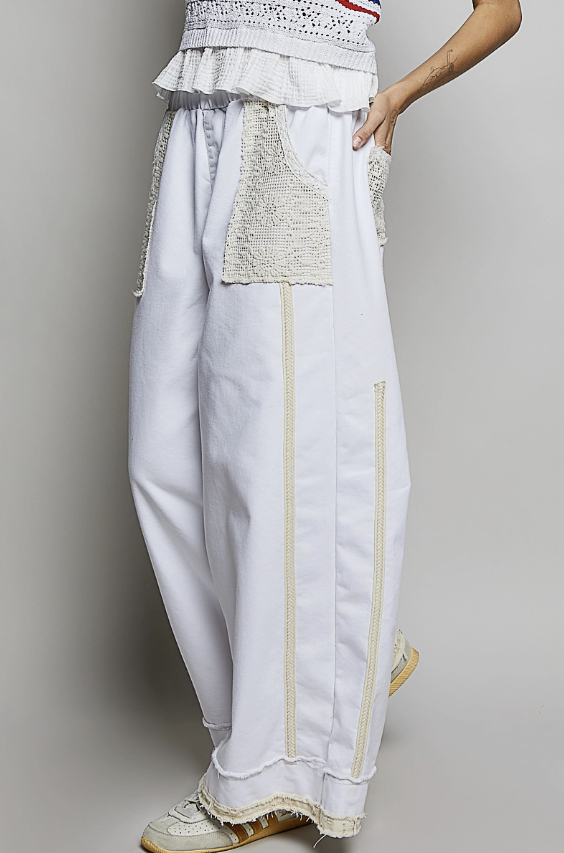 Woman wearing white and lace pant on plain background