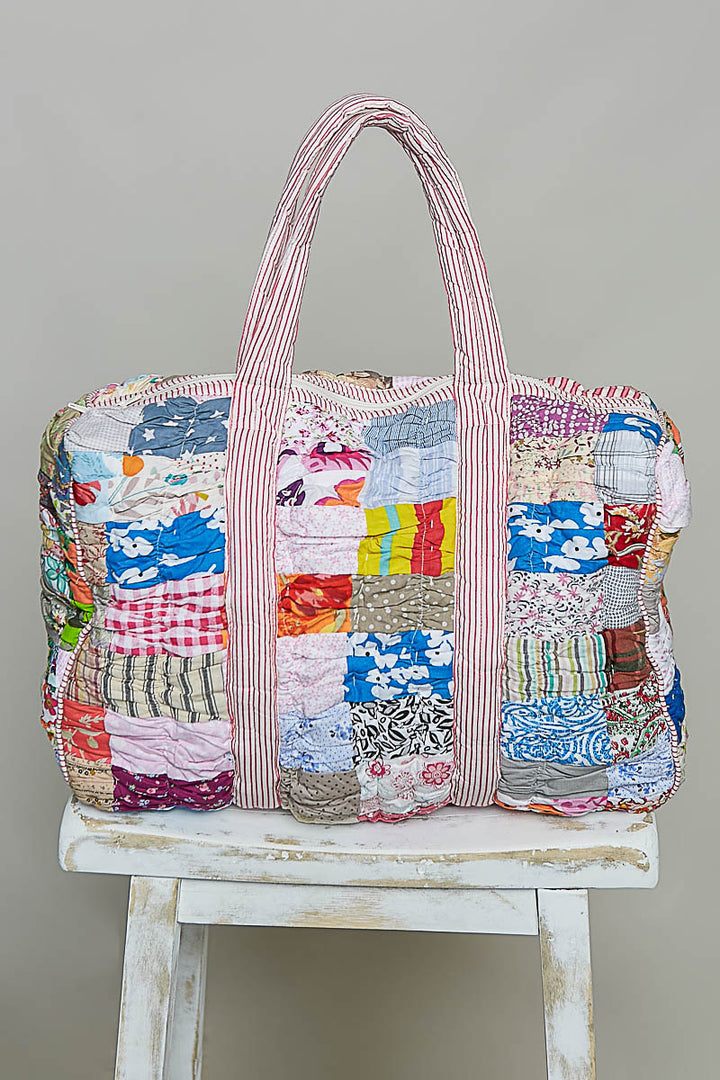 quilted bag on stool on plain background