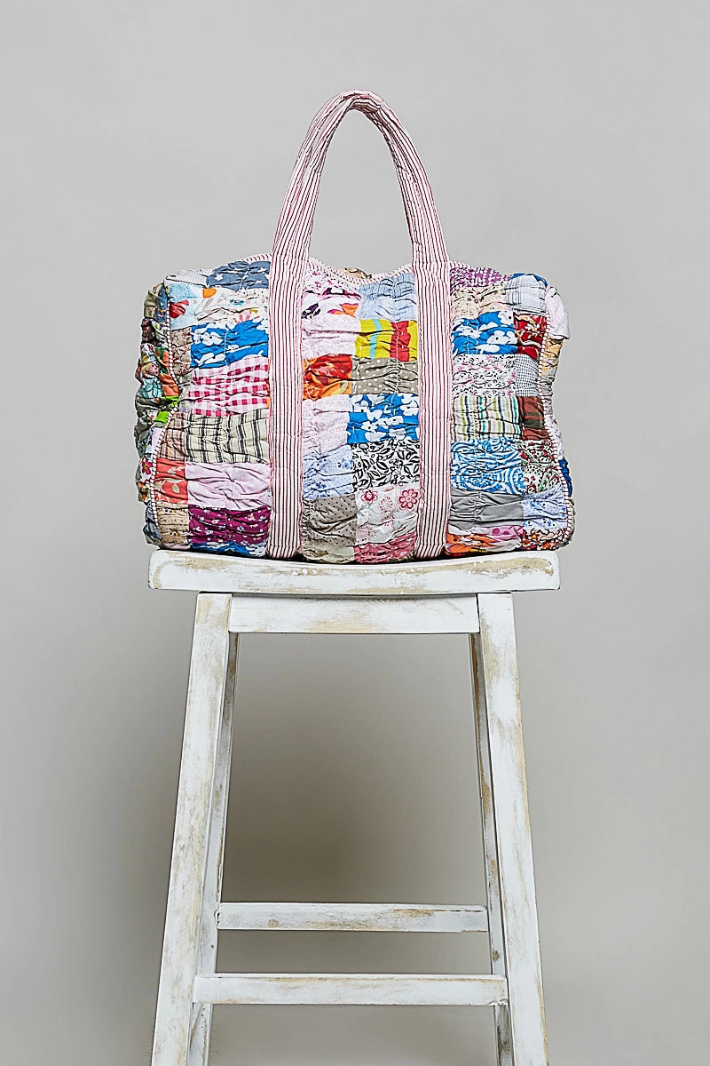 quilted bag on stool on plain background