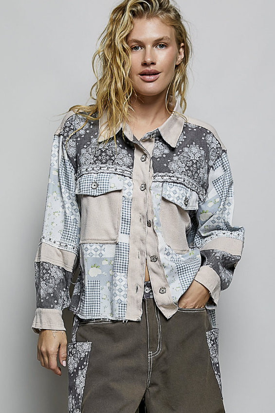 Woman wearing a patchwork shirt with a neutral background