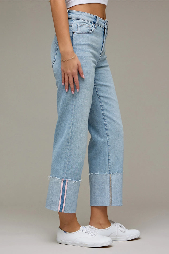 Light blue jeans with a striped hem worn by a person on a neutral background