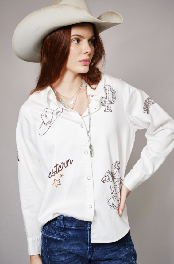 Woman wearing a white embroidered shirt with cowboy hat on a gray background
