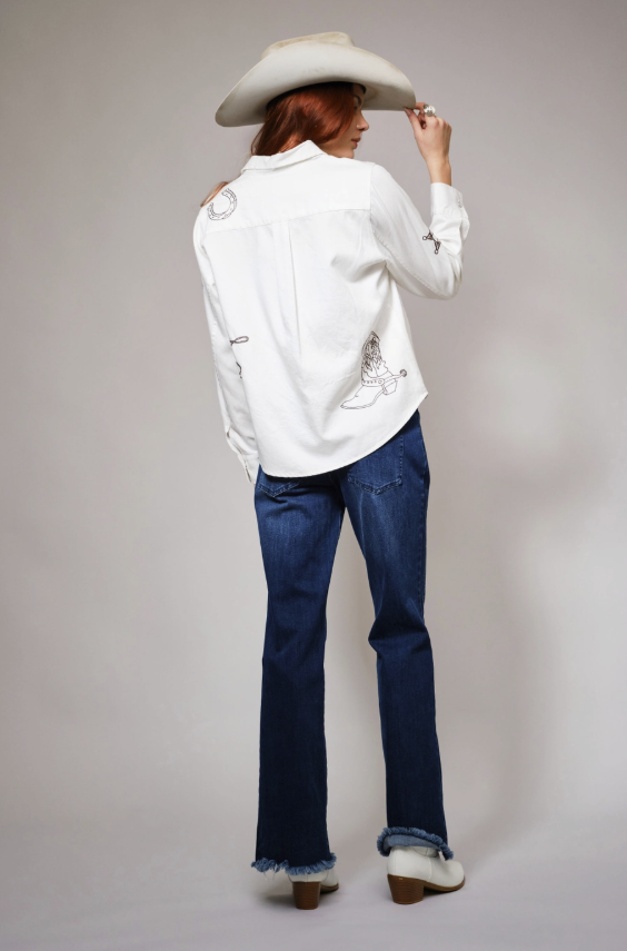 Person wearing a white shirt, blue jeans, and a cowboy hat on a plain background