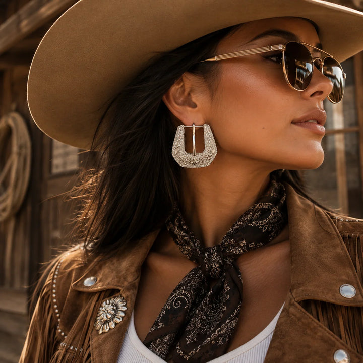 Woman wearing cowboy hat and sunglasses with mini buckle earrings in silver