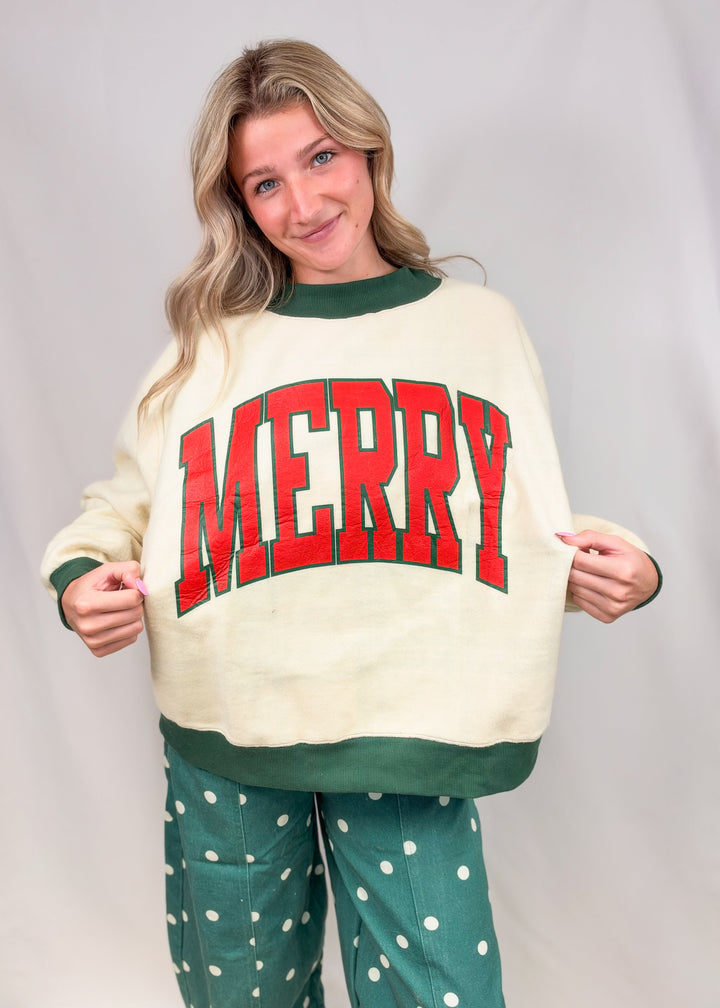 Woman wearing beige mock neck sweatshirt with &