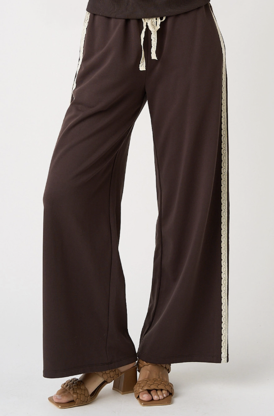 Brown wide-leg pants with white trim on a white background