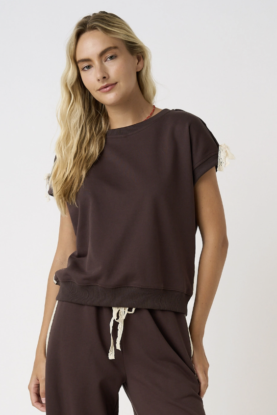 Woman wearing brown tee on white background