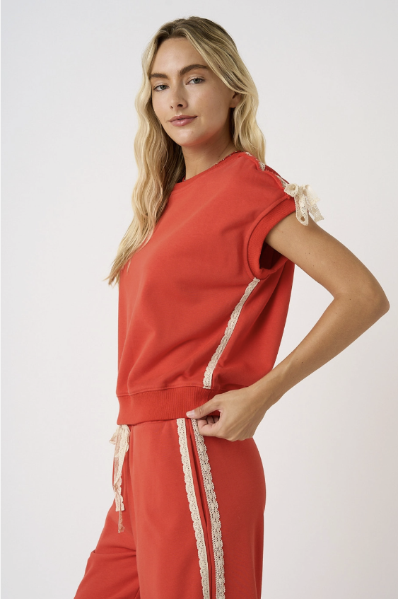 Woman wearing matching red set with lace detail on white background