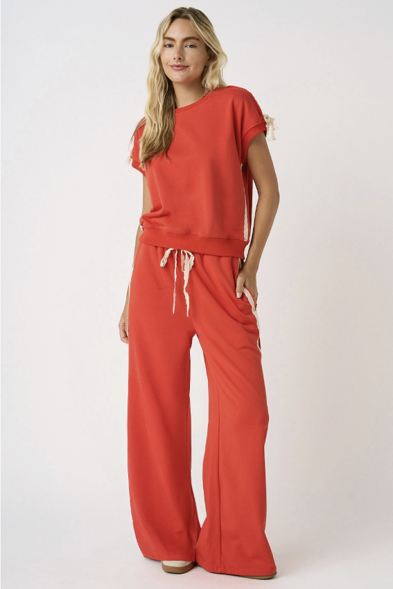 Woman wearing matching red set with lace detail on white background