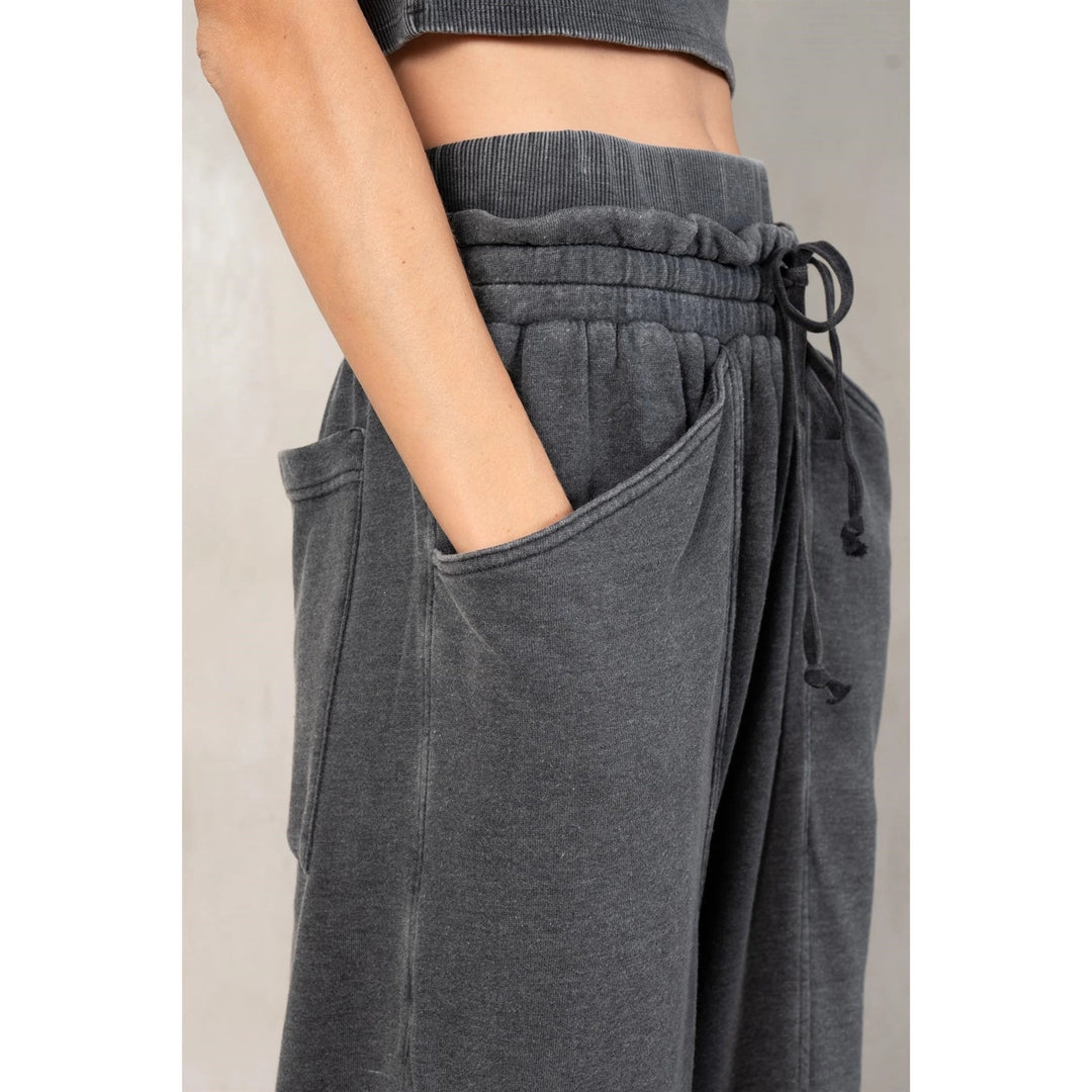 Gray sweatpants with a drawstring waist on a neutral background