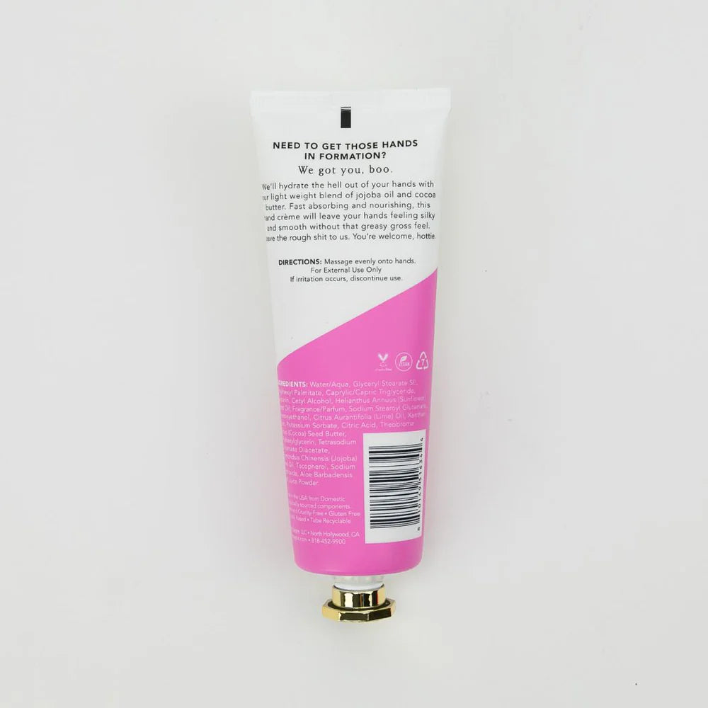 A squeeze tube of hand cream or lotion shown from the back, featuring a white upper section with black text and a bright pink lower section with a gold cap, set against a plain white background.