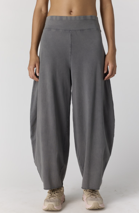 Woman wearing grey pants on plain background