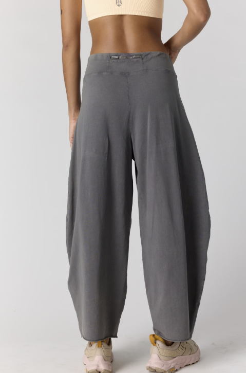 Back of woman wearing grey sweatpants on plain background