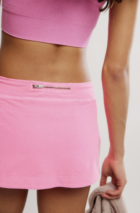 Woman wearing hot pink mini skort on white background