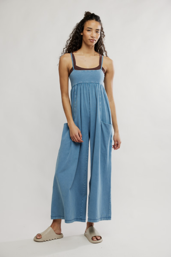 Woman wearing blue onesie on plain background