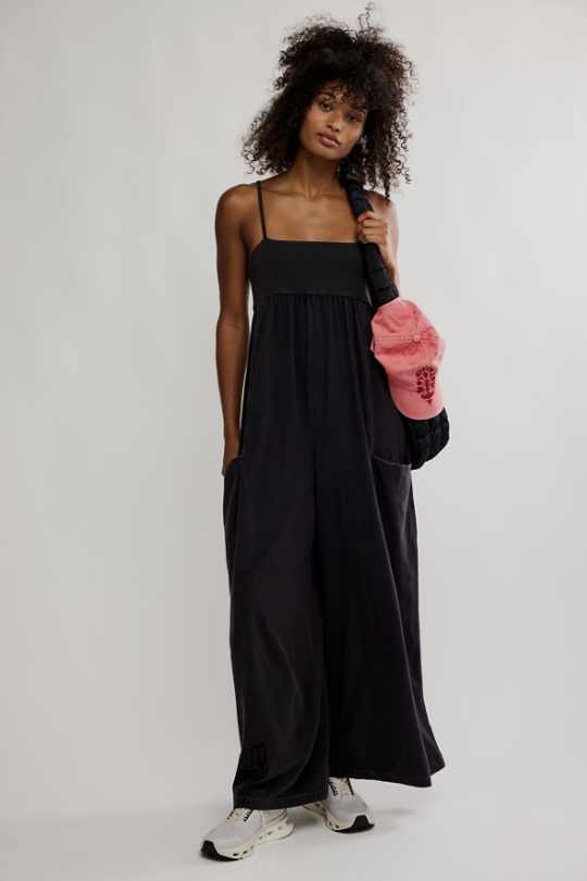 Woman wearing black one piece on plain background