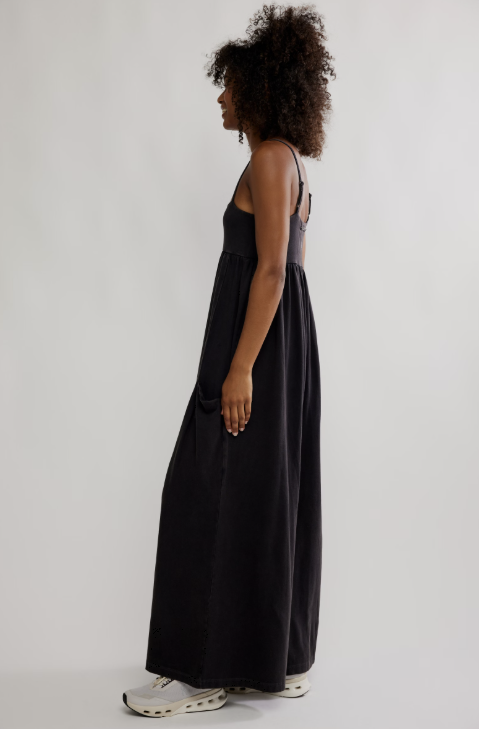 Woman wearing black onesie on plain background