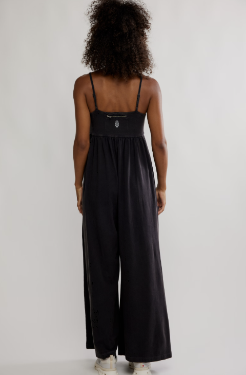 Woman wearing black one piece on plain background