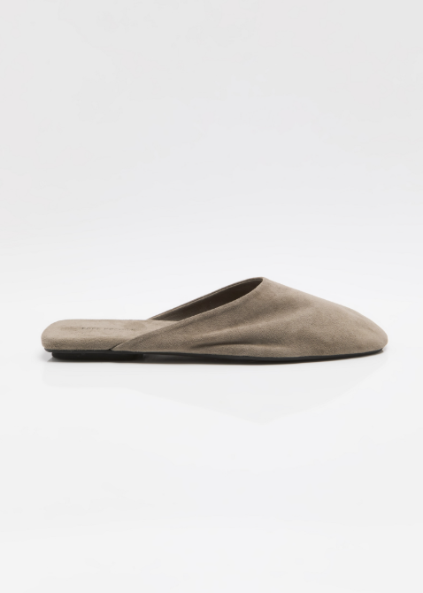 Single beige mule shoe on white background