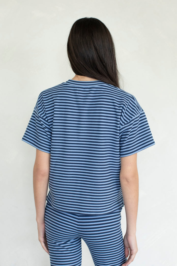 Person wearing a blue and white striped outfit against a plain background