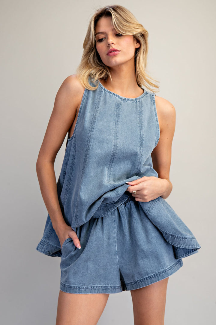 Woman wearing matching denim set on plain background