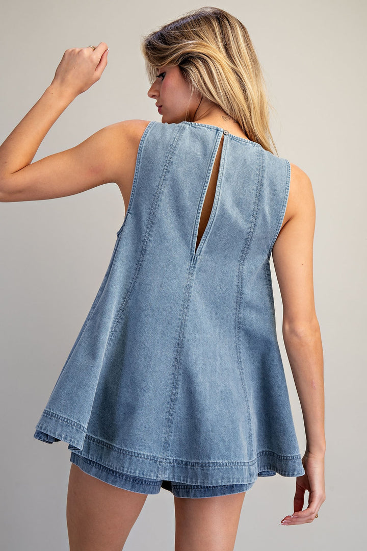 Back of woman wearing denim matching set on plain background