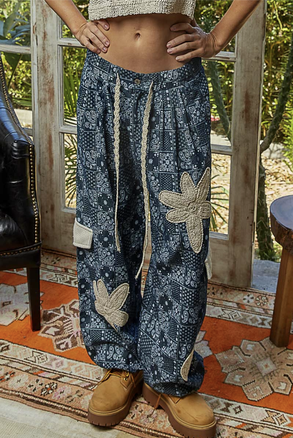 Person wearing blue patterned pants with floral designs indoors.