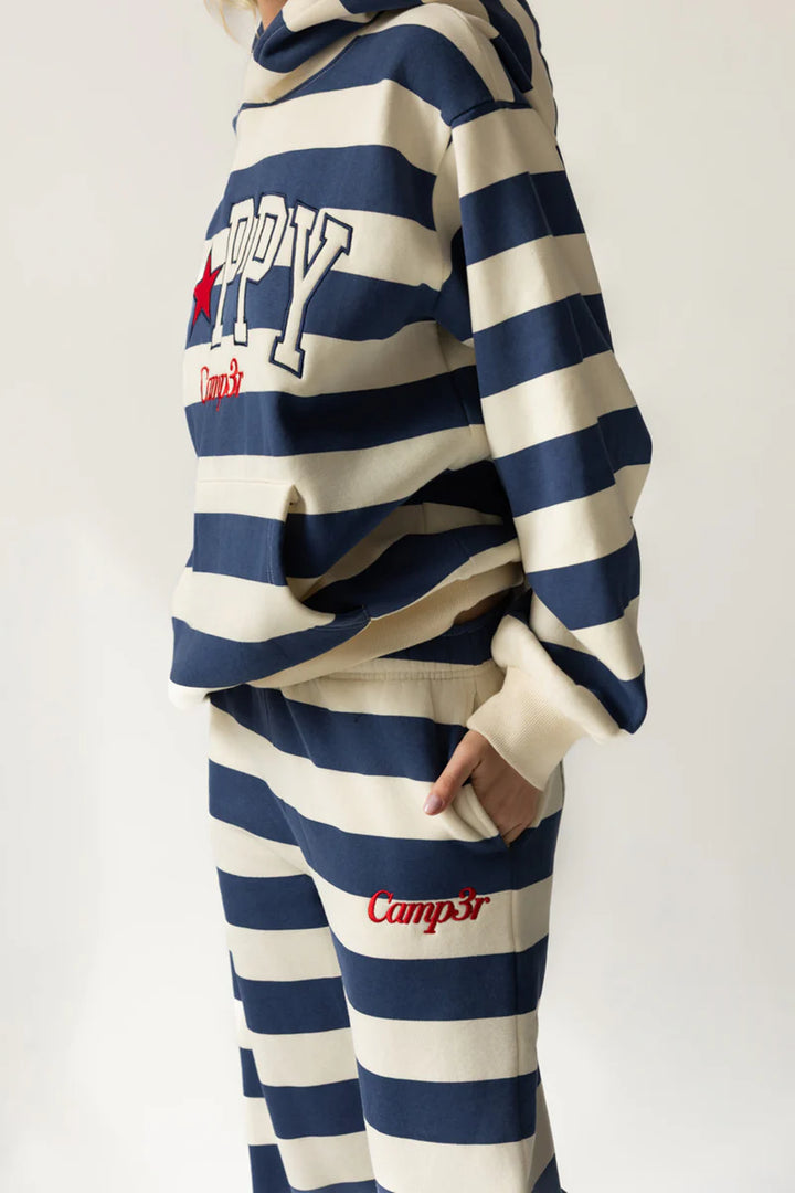 Person wearing a blue and white striped hoodie and pants with &