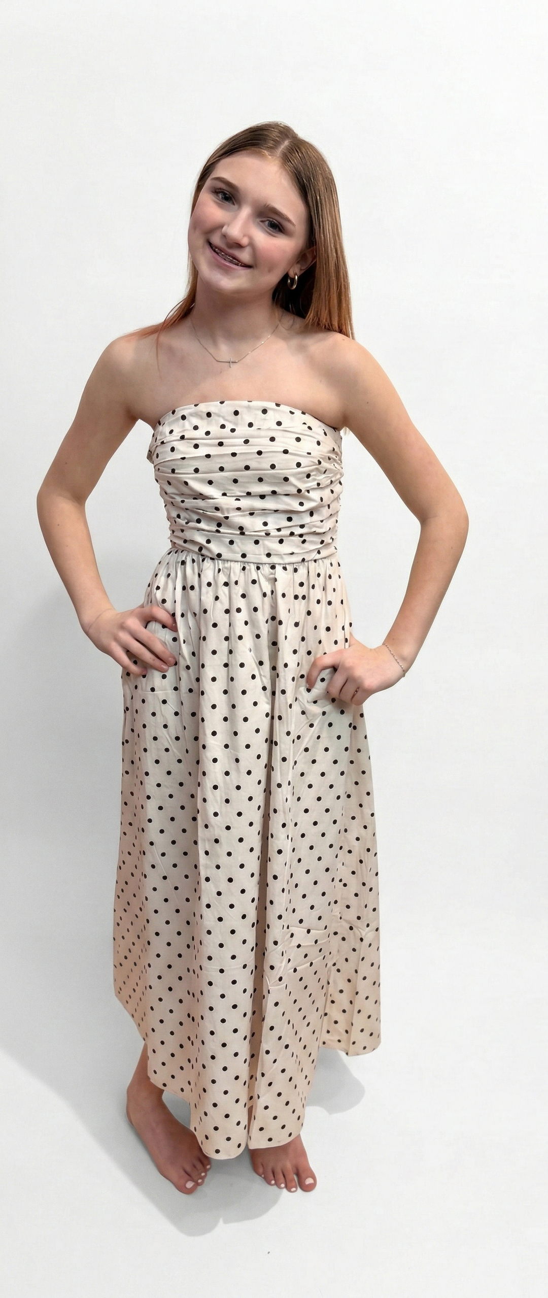 Woman wearing polka dot dress on plain background