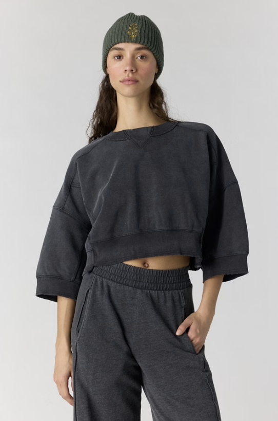 Woman wearing black sweatshirt on plain background