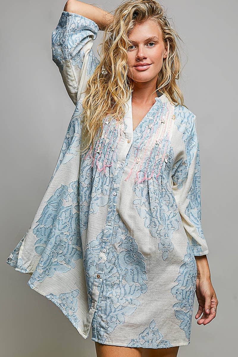 Woman wearing embroidered dress on plain background
