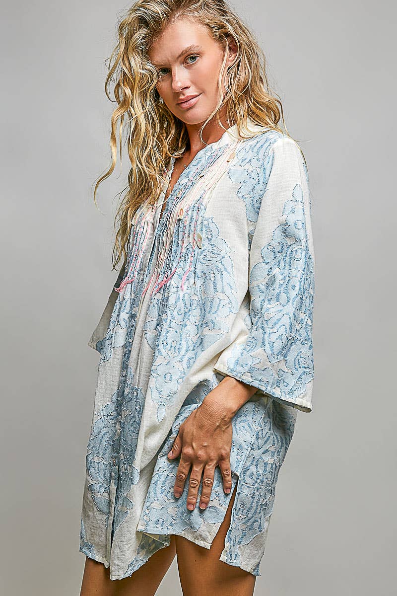 Woman wearing embroidered dress on plain background