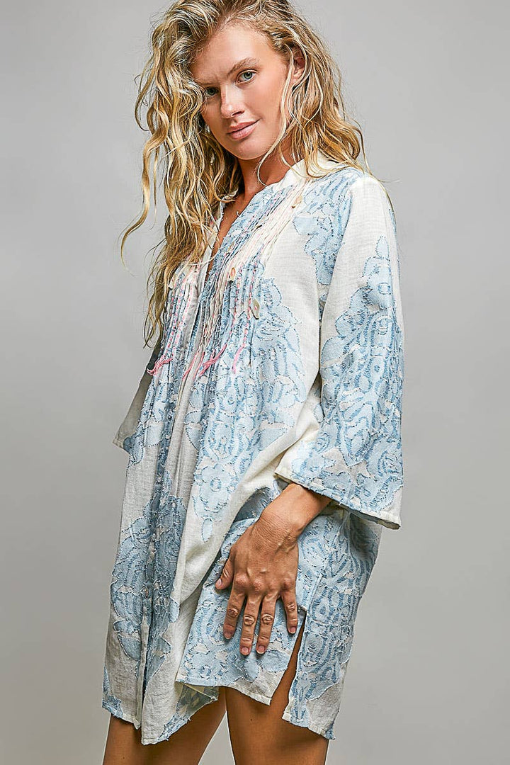 Woman wearing embroidered dress on plain background
