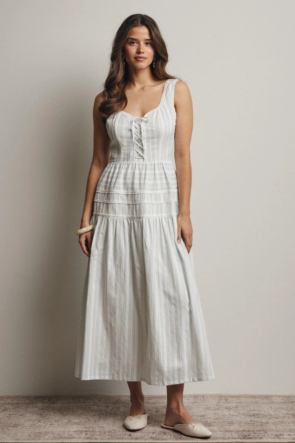 Woman wearing a white dress against a plain background