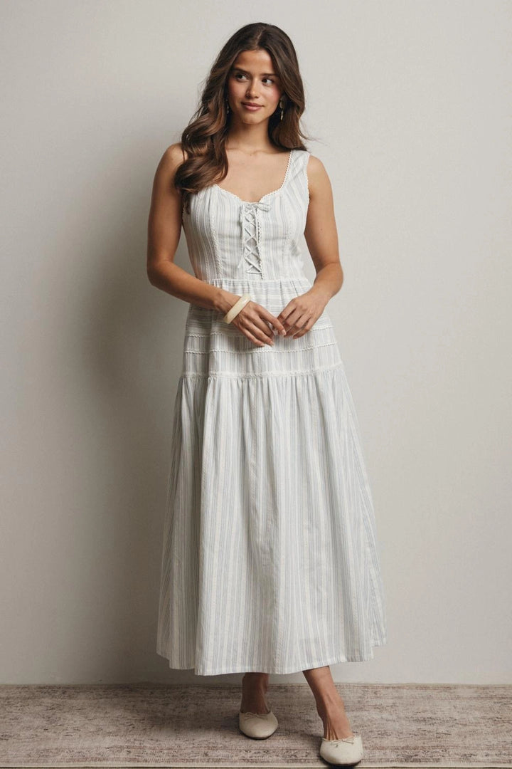Woman wearing a white dress against a plain background