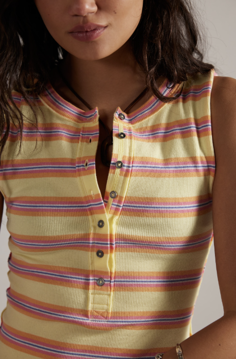 Close-up of a person wearing a sleeveless striped shirt with a neutral background