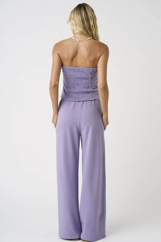 Woman wearing matching purple set on white background