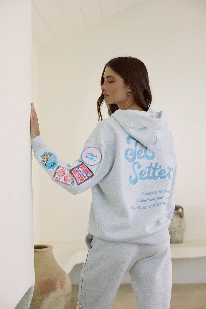 Woman wearing grey sweatshirt with embroidery detail and patches 